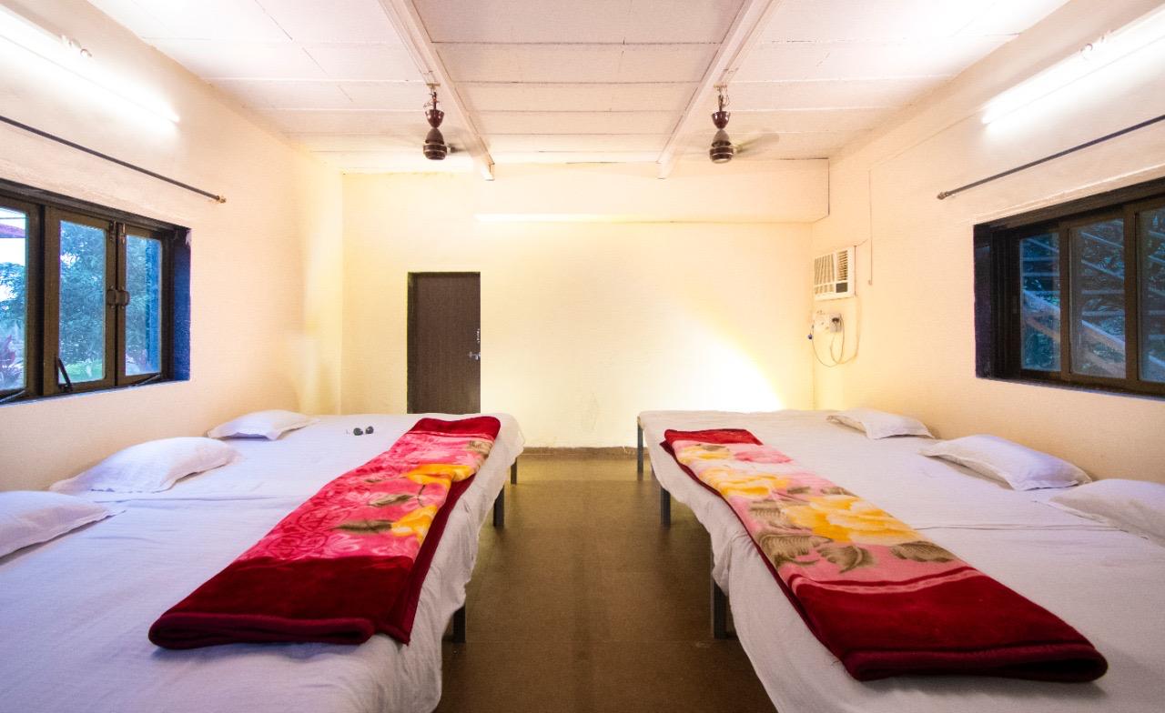 Comfortable family cottage room with four single beds and neat bedding