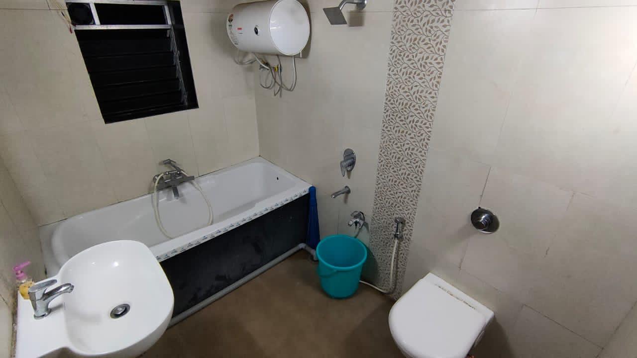 Contemporary bathroom interior with bathtub, sink, toilet, and clean tiling