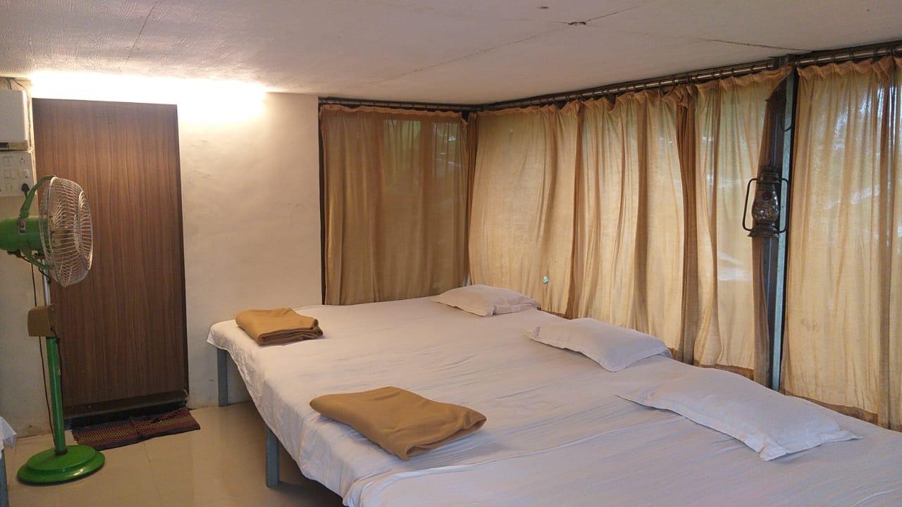 Spacious group stay dormitory room with comfortable beds and clean curtains