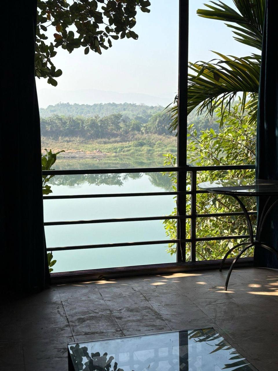 Peaceful Vaitarna River view from the balcony window framed by trees